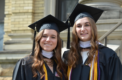 Laura Sonday takes a photo with Julia Boeve (St. James, Minn.), fellow senior on the women’s tennis team, during the spring 2019 commencement on the Winona Campus.