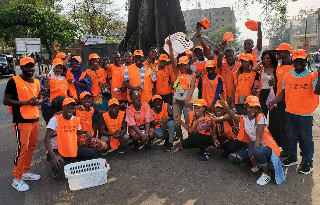 Members of Social Workers Sierra Leone take a group photo clad in their bright orange gifts, which were donated from Sylvester Amara Lamin, associate professor of the MSW program.