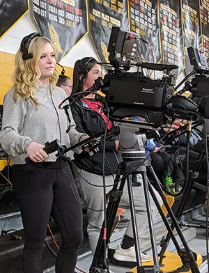 Saint Mary's students Grace Gilles, left, and Allison Grengs operate the cameras of a high school basketball game for HBC TV-25.