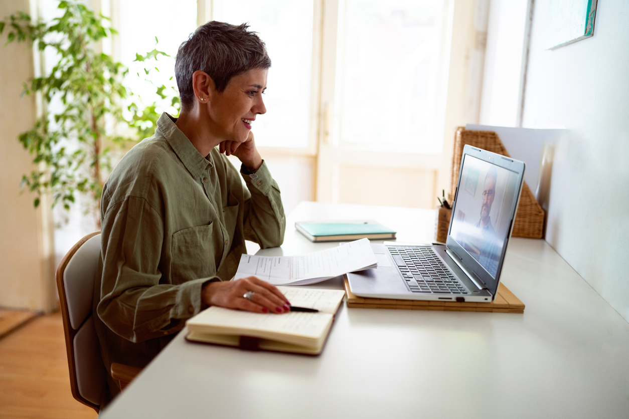 Student in online course sitting at desk in home office