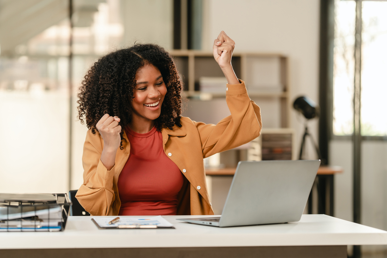 Online student at computer celebrating achievement