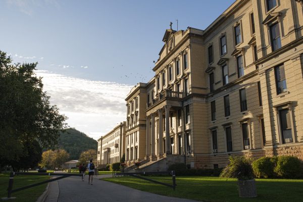 Large historical building with students walking in front.