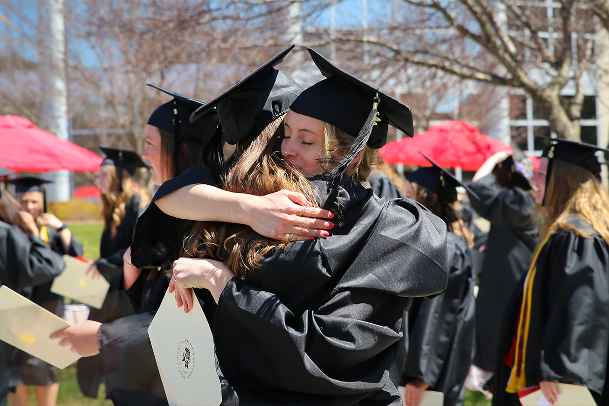 Two Saint Mary's graduates hug each other following the commencement ceremony.